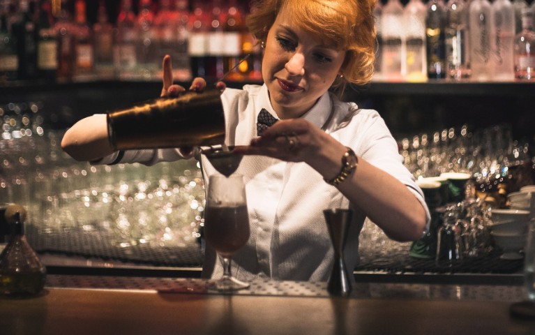 barmaid o barlady prepara un cocktail